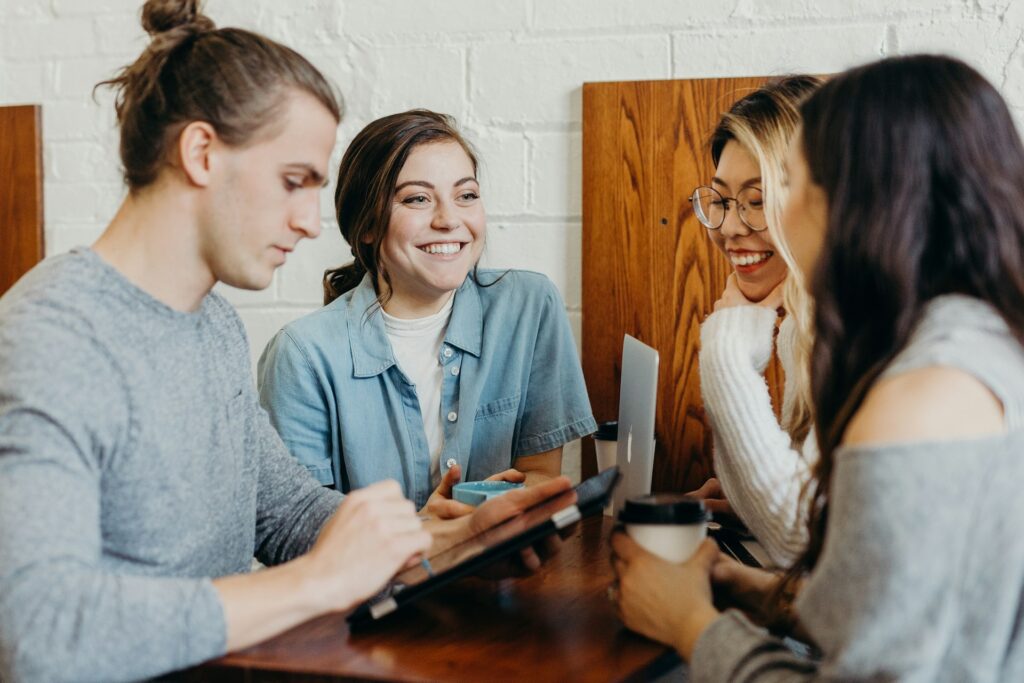 Four women seated around a table, engaged in a group discussion.