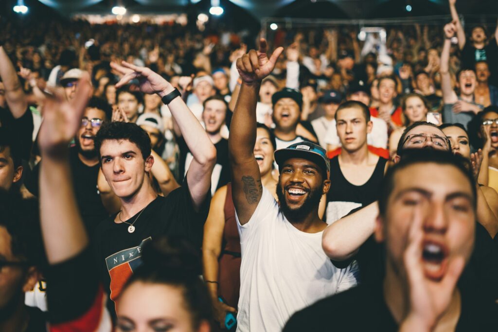 An image depicting a large crowd in a city, likely attending a concert, capturing the lively and energetic atmosphere.