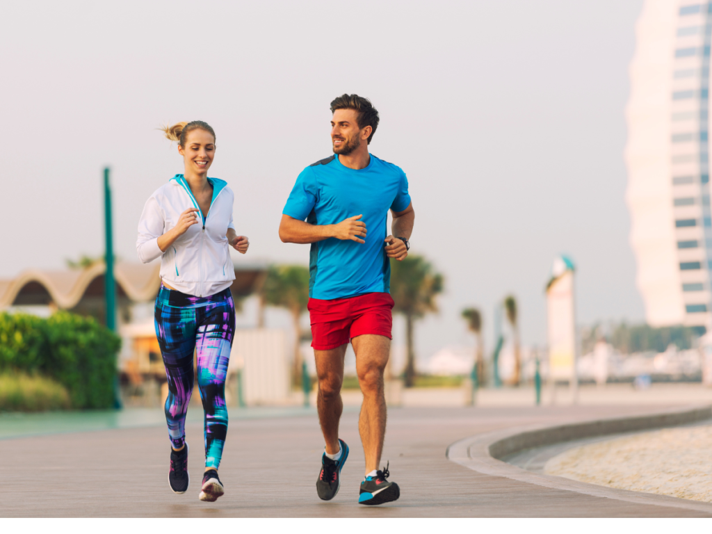 A man and a woman jog side by side in Dubai to stay motivated while exercising. 