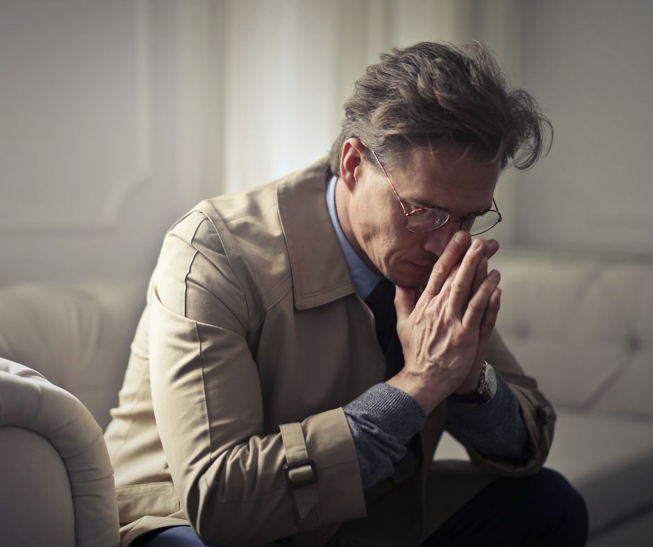 A man displays loneliness by sitting alone indoors