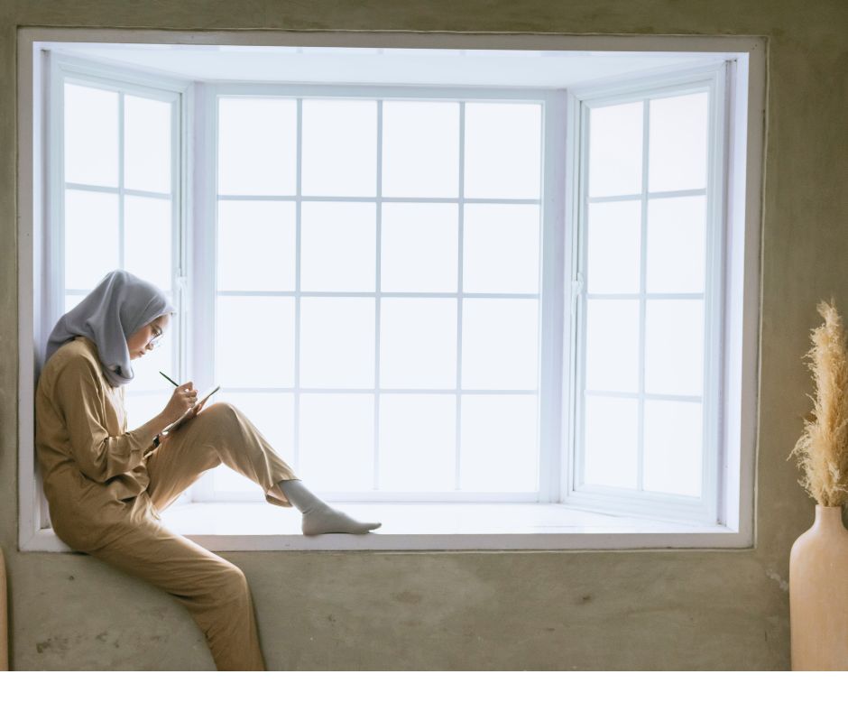 a woman writes on a notebook